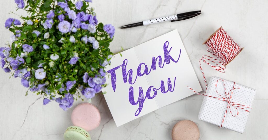 An elegant thank you card with flowers and a gift on a marble surface, perfect for expressing gratitude.